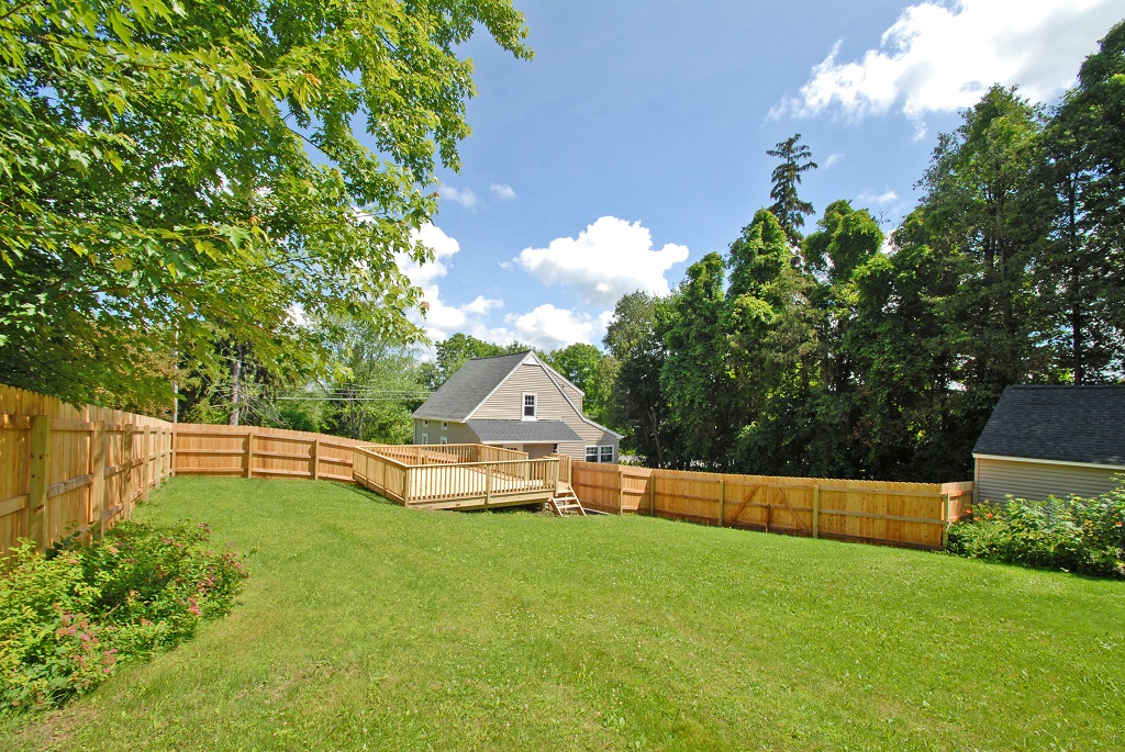 Expansive backyard with spacious deck and privacy fencing
