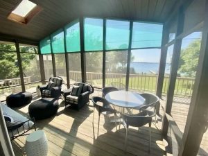 Screened in porch overlooking back yard & lake